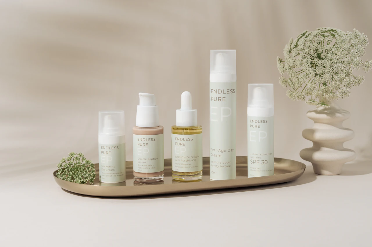 Bandeja com frascos de skincare e um pequeno vaso de flores